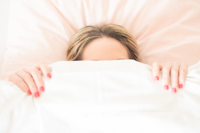 Mujer descansando en la cama por agotamiento emocional
